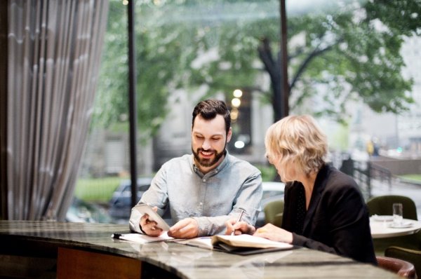 2 people seated discussing the budget 