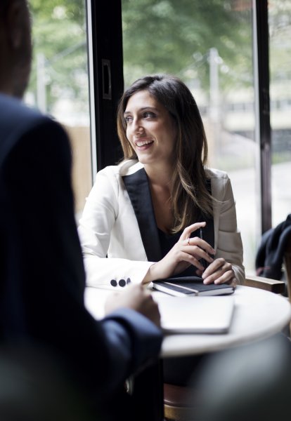 person sharing business information with others seated at a table 