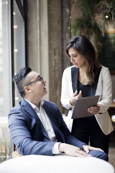 2 team members sharing info on a tablet 