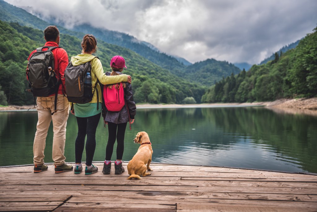 family of 3 and a dog by a lake 