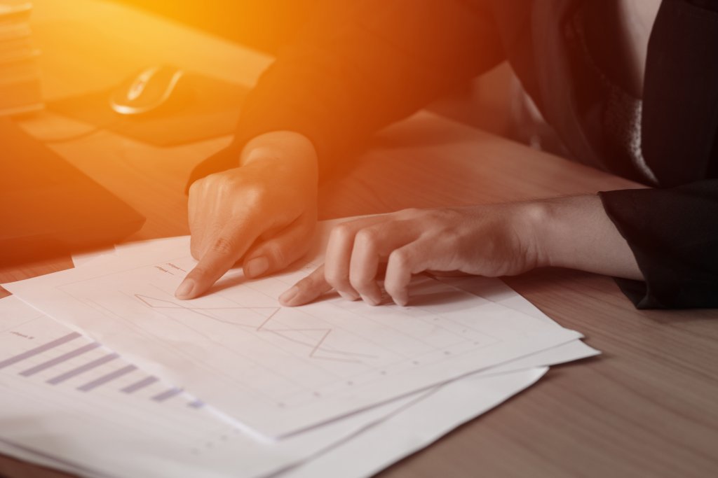 person seated a desk deciphering some graphs 