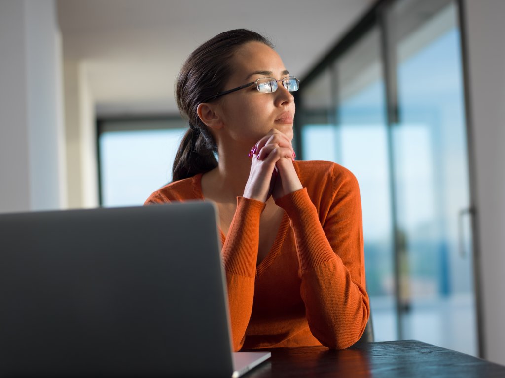 Une personne pensive qui regarde par la fenêtre