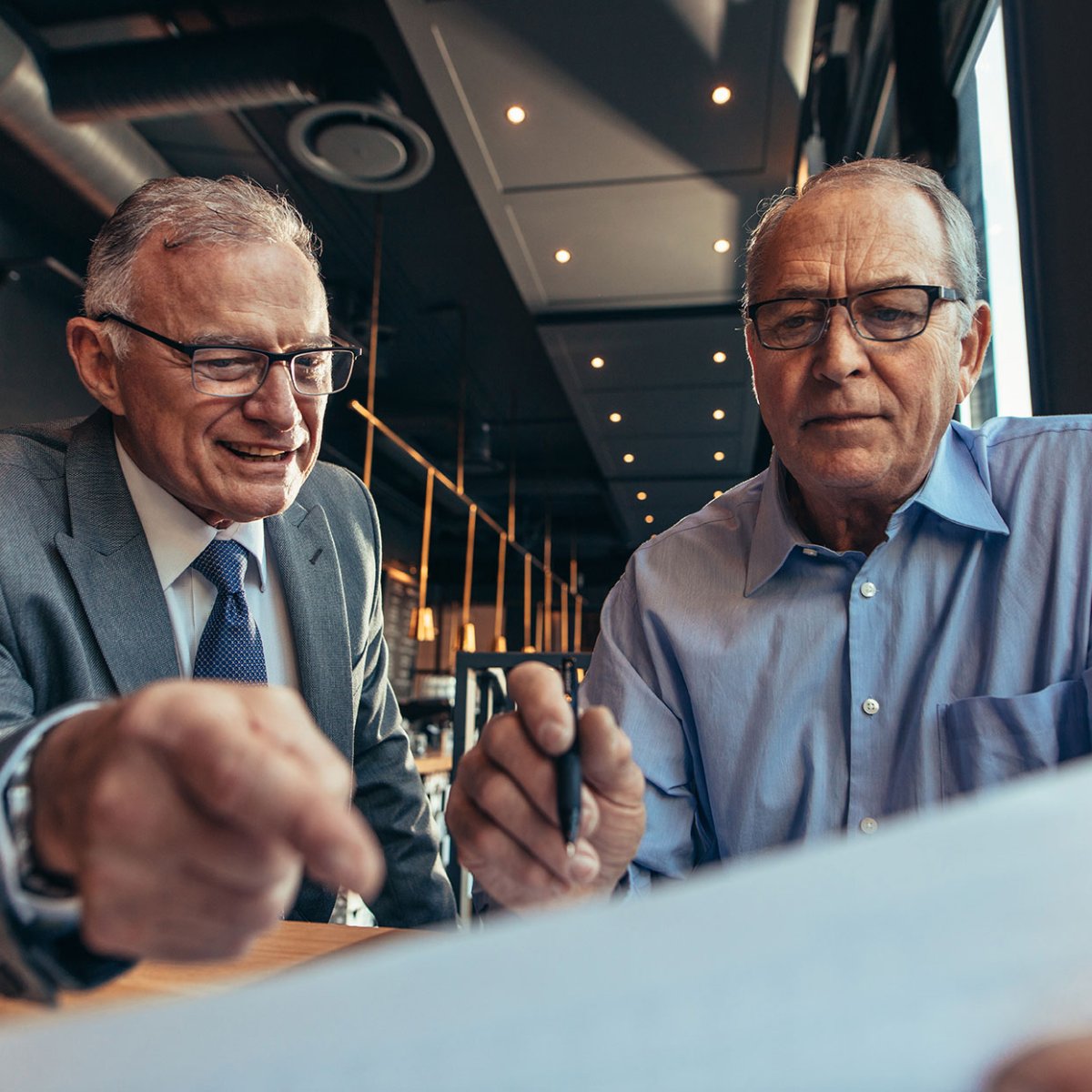 Two men talking about a business document